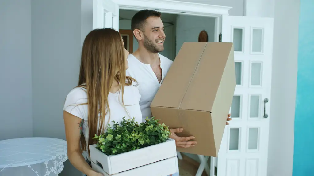 Couple carrying moving boxes into their new Kansas City rental home