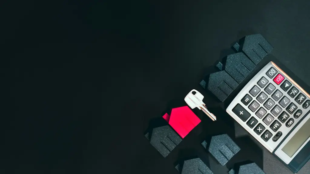 House keys, model home and calculator on an investor's desk